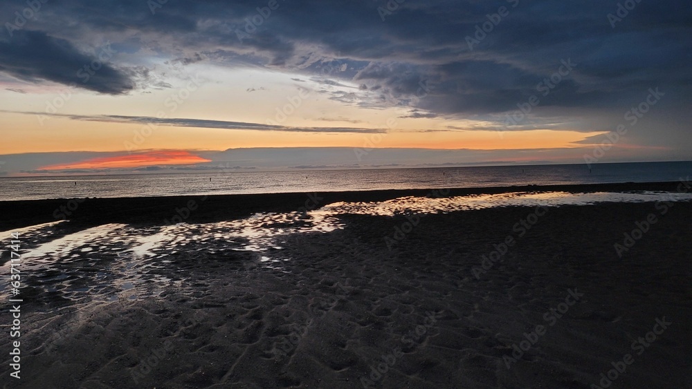 Scenic view of a beautiful sunset over Lake Ontario and a sandy beach in Canada