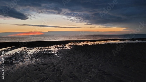 Scenic view of a beautiful sunset over Lake Ontario and a sandy beach in Canada © Alejandro Montemayor/Wirestock Creators