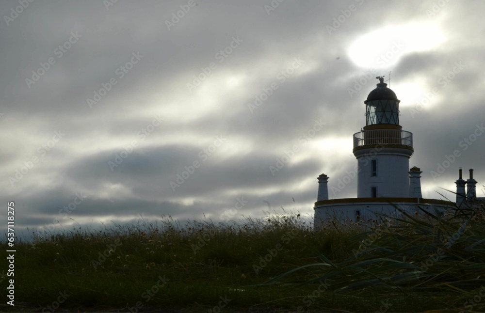 Lighthouse on the shore under a cloudy sky