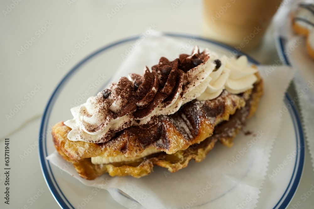 Closeup of fresh waffles with whipped creamy and cocoa topping on a plate Closeup of fresh waffles with whipped creamy and cocoa topping on a plate