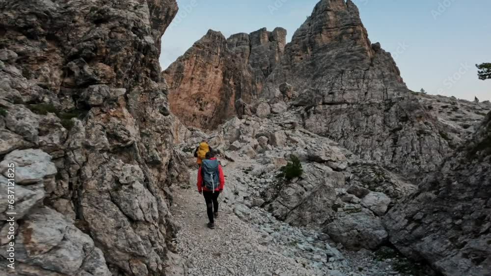 Active people with backpacks hiking trail path and climbing Dolomites mountain.Group of friends summer adventure journey in nature outdoors. Travel exploring Alps, Dolomites, Italy Active people with backpacks hiking trail path and climbing Dolomites mountain.Group of friends summer adventure journey in nature outdoors. Travel exploring Alps, Dolomites, Italy