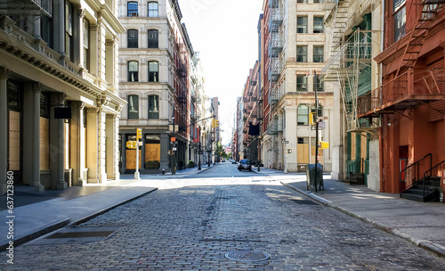 Empty streets and sidewalks of Soho are eerily quiet during the 2020 coronavirus pandemic lockdown in New York City with no people and sunset background © deberarr