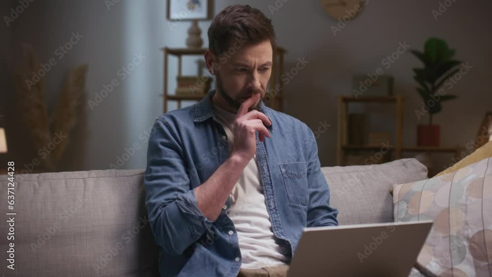 Man working late in evening. Male sitting at couch and using tablet. Thoughtfull man working distantly. Bearded man wearing wireless headphones. Serious man resolving business issues. Man working late in evening. Male sitting at couch and using tablet. Thoughtfull man working distantly. Bearded man wearing wireless headphones. Serious man resolving business issues.