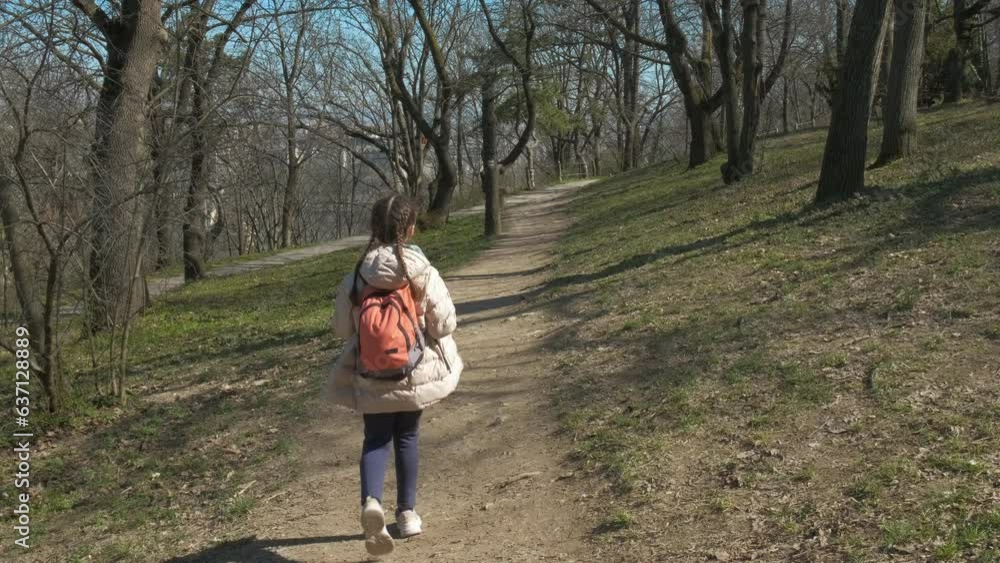 Alone child promenade on path. A view of alone child have a promenade on the park path in the day light. Alone child promenade on path. A view of alone child have a promenade on the park path in the day light.