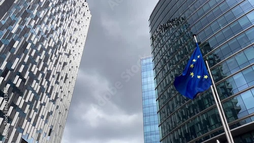 European Union flags flutter in wind against glass building facade background, Brussels, Belgium, Europe, August 5, 2023. High quality 4k footage photo