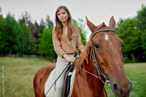 Equine expedition. A charming female rider in beige blouse on her brown horse. Bond with animals, de-stress, and explore nature for emotional well-being. Emotion-filled horse riding lesson gift