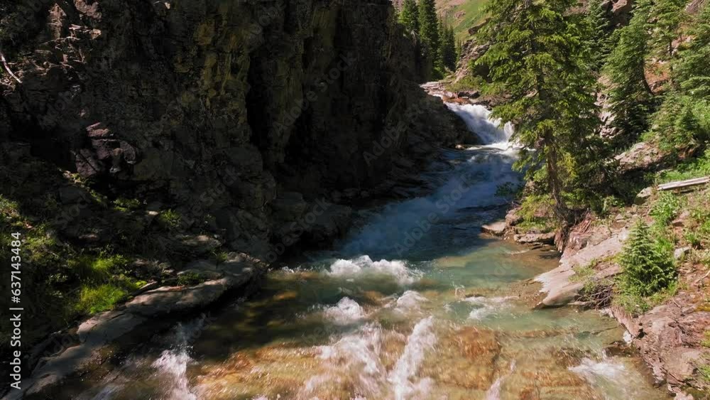 Aerial view over alpine stream with rocky cliff walls Aerial view over alpine stream with rocky cliff walls