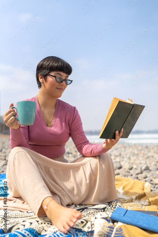 Woman reading relaxed a book and drinking coffee outdoors