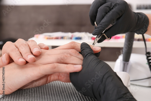 Professional manicurist working with client in salon, closeup