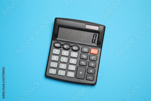 Calculator on light blue background, top view. Office equipment