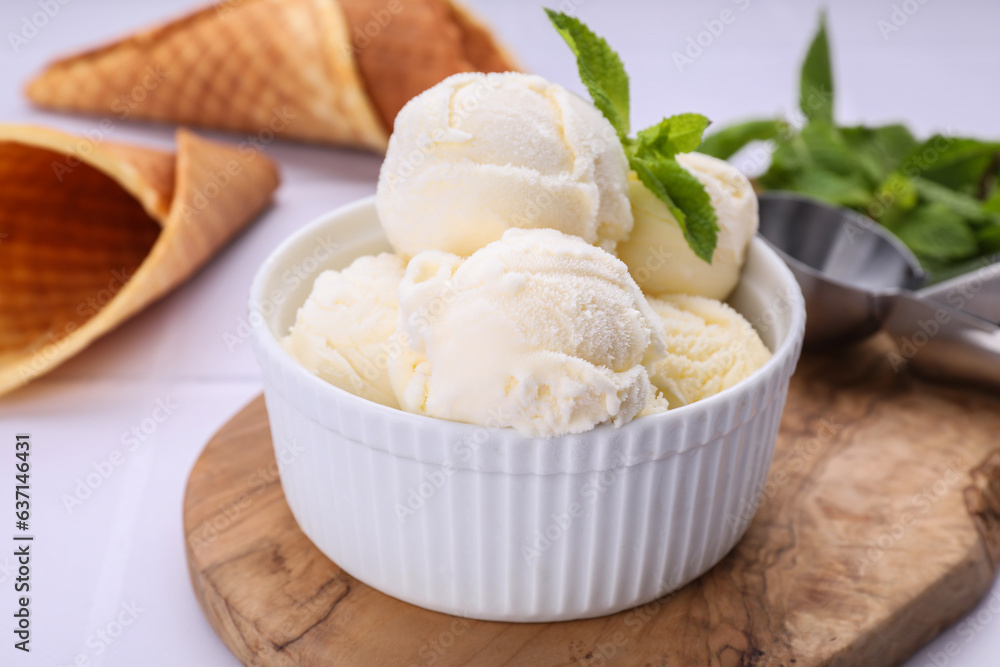 Bowl of ice cream and mint leaves on white table, closeup Bowl of ice cream and mint leaves on white table, closeup