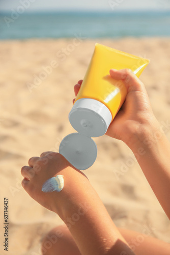 Child applying sunscreen near sea, closeup. Sun protection care