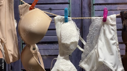 Women's bras and panties hung from a rope in a lingerie store window