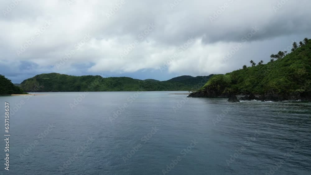 Overcast grey clouds above blue ocean water and rocky tropical coastline, space for text Overcast grey clouds above blue ocean water and rocky tropical coastline, space for text