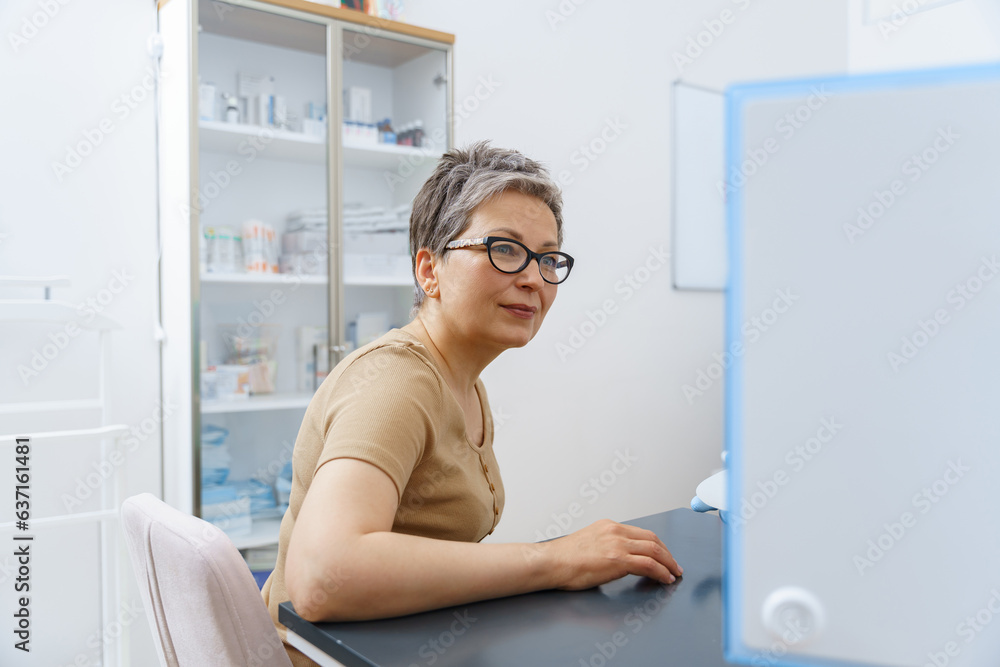 Woman sitting in doctor's office during appointment and looking at side. High quality photo Woman sitting in doctor's office during appointment and looking at side. High quality photo