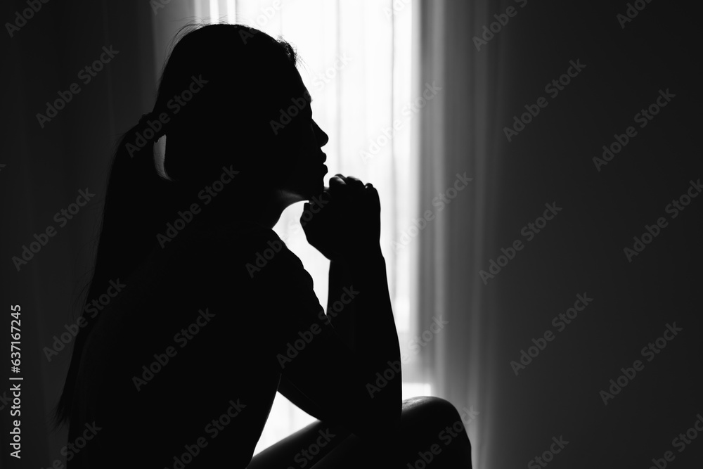 Silhouette of Religious young woman praying to God in the morning, spirtuality and religion,  Christians and Bible study concept.