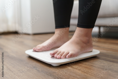 Fat diet and scale feet standing on electronic scales for weight control. Measurement instrument in kilogram for a diet control.