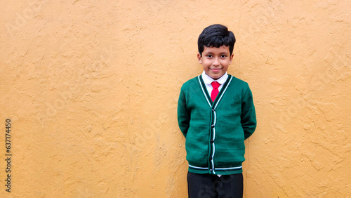 Dark-haired 9-year-old Latino boy in a public school uniform is excited and happy about the return to school ready to study
