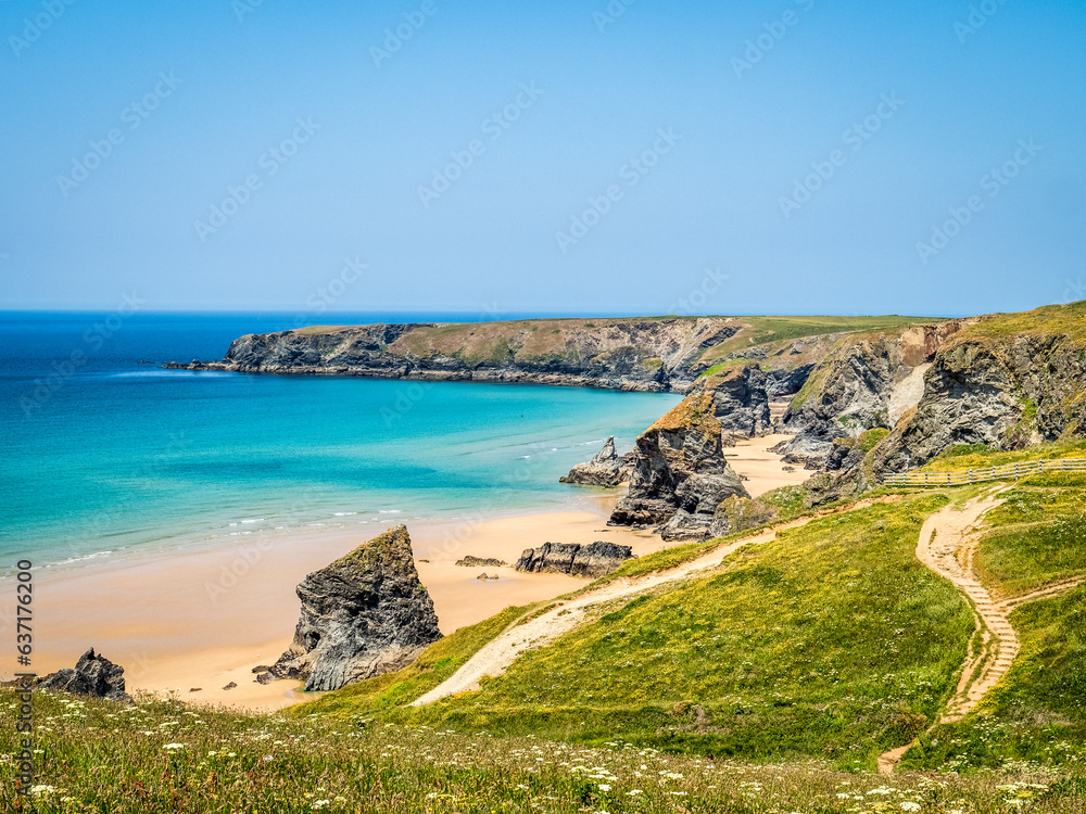Bedruthan Steps in summer, with wildflowers, clear blue sky and sunshine, Cornwall, UK.