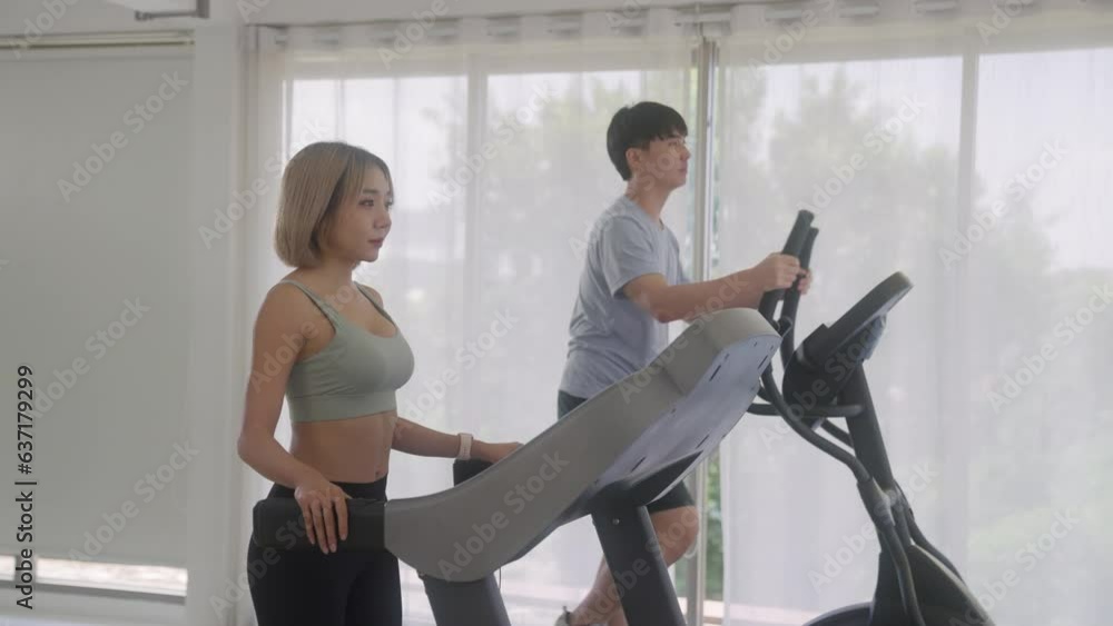 Attractive asian girl running on the treadmill in the sport gym. Attractive asian girl running on the treadmill in the sport gym.