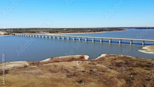Wallpaper Mural Flying diagonally over the shoreline towards the large 4 lane bridge crossing the lake; large eighteen wheeler crossing the bridge. Bright blue water and sky which is cloudless Torontodigital.ca