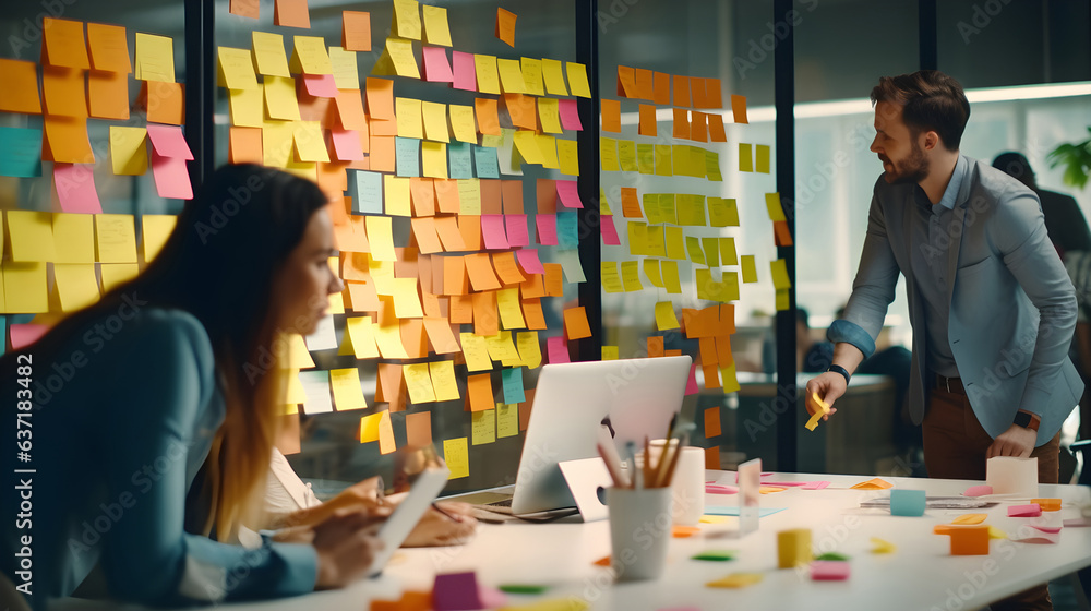 A man and woman team organizing and analyzing sticky notes on a wall in a modern office - obrazy, fototapety, plakaty 