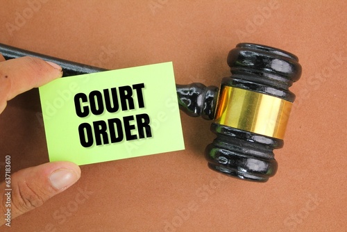 judge's gavel and hand holding a paper with the word court order. concept of court or law. the concept of judgment in court