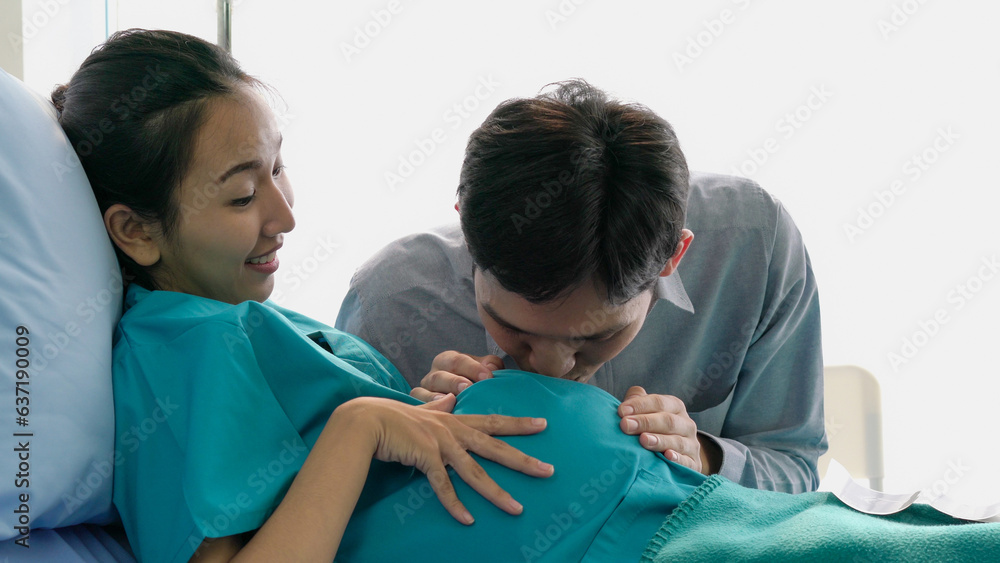 Husband kisses pregnant wife's belly. Husband kisses pregnant wife's belly.