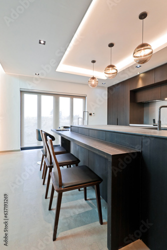 The island table and the chairs next to each other create a bar-like feel