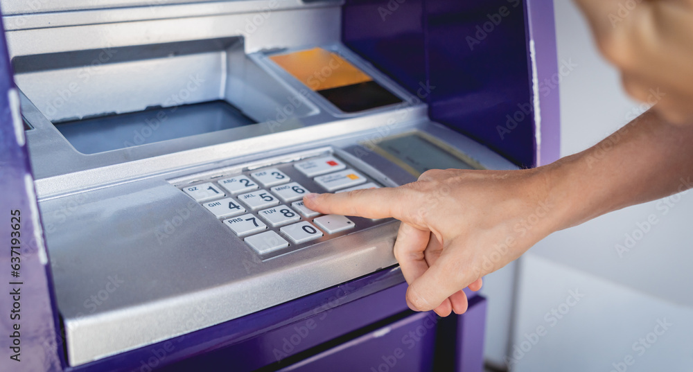 Young woman using the card for withdrawing the cash in the ATM Young woman using the card for withdrawing the cash in the ATM