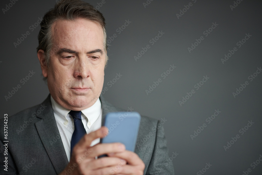 Portrait of serious businessman reading news and notifications on smartphone Portrait of serious businessman reading news and notifications on smartphone