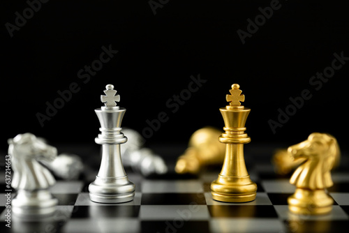 Golden and Silver King chess standing in front of other chess on chess board.