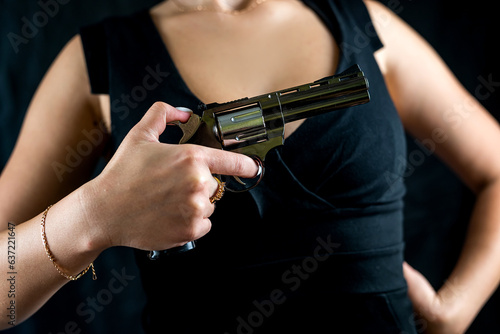 cropped photo of woman in dress with revolver inhand for shooting isolated on black background