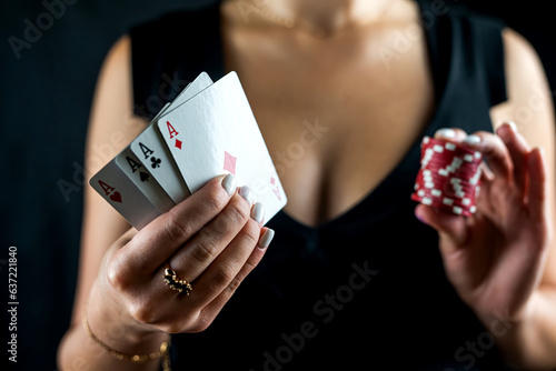 beautiful woman playing poker holding casino chips and dollars and enjoying winning.