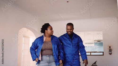 Black Couple Wearing Blue Overalls and Discussing Their DIY Plans photo