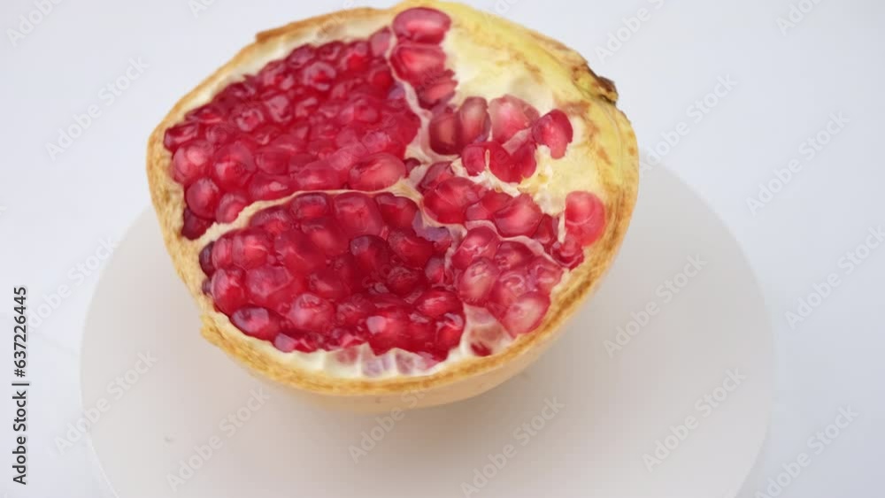 Juicy pomegranate cut in half isolated on white background, clipping path. Ripe fruit is a healthy food. Juicy pomegranate cut in half isolated on white background, clipping path. Ripe fruit is a healthy food.