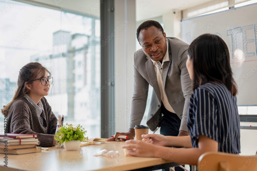 A professional African American male teacher teaching English for Asian students in the class A professional African American male teacher teaching English for Asian students in the class