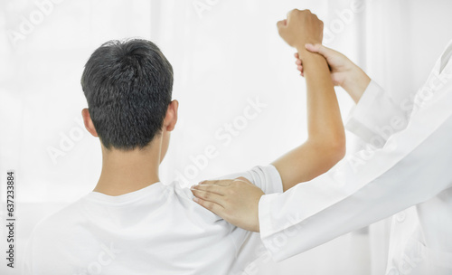 Fotografie, Obraz Female physiotherapists provide physical assistance to male patients with shoulder injuries massaging their shoulders for muscle recovery in the rehabilitation center