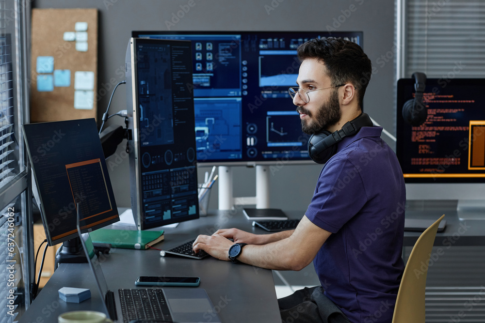 © Westend61 - Young computer programmer with wireless headphones coding on desktop PC