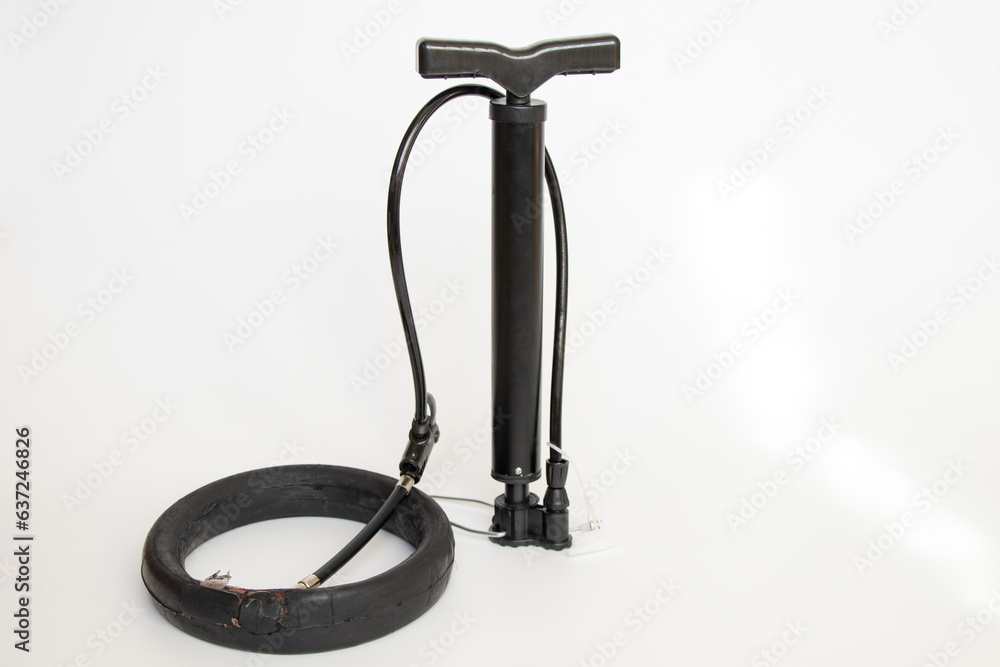Glued camera of an electric scooter and a hand pump pumps the camera on a white background, repair and replacement of the wheel, puncture of the wheel and camera Glued camera of an electric scooter and a hand pump pumps the camera on a white background, repair and replacement of the wheel, puncture of the wheel and camera