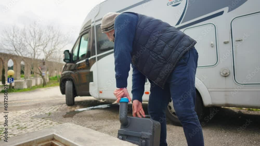 Man pours toilet cassette from RV into black water sink Man pours toilet cassette from RV into black water sink
