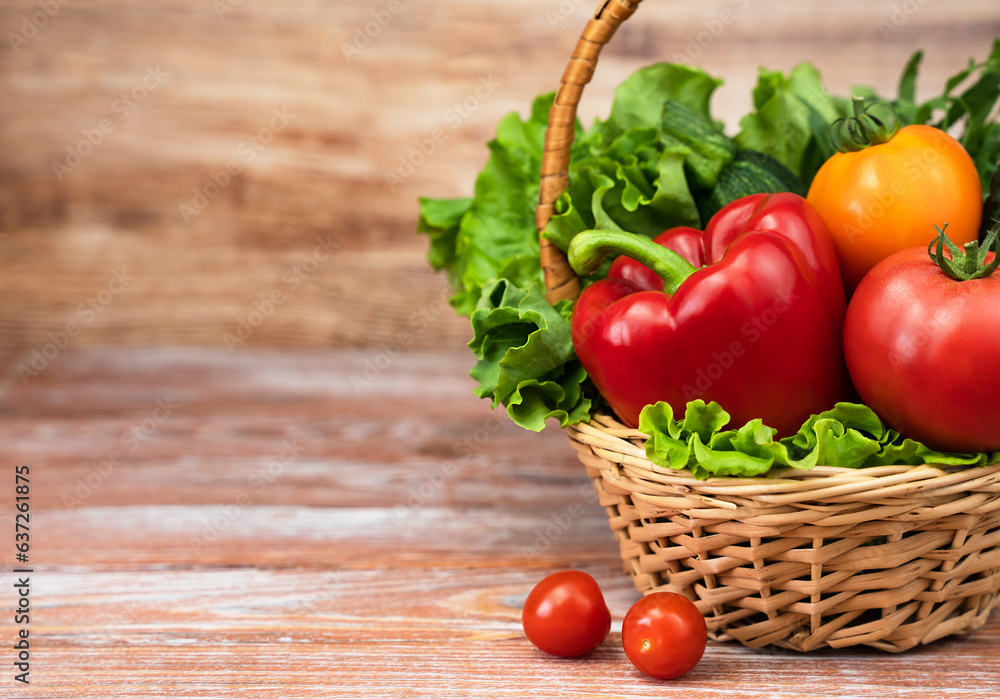 Fresh vegetables and greens in a wicker basket on a wooden background. Harvesting. Thanksgiving Day. Copy space. Fresh vegetables and greens in a wicker basket on a wooden background. Harvesting. Thanksgiving Day. Copy space.