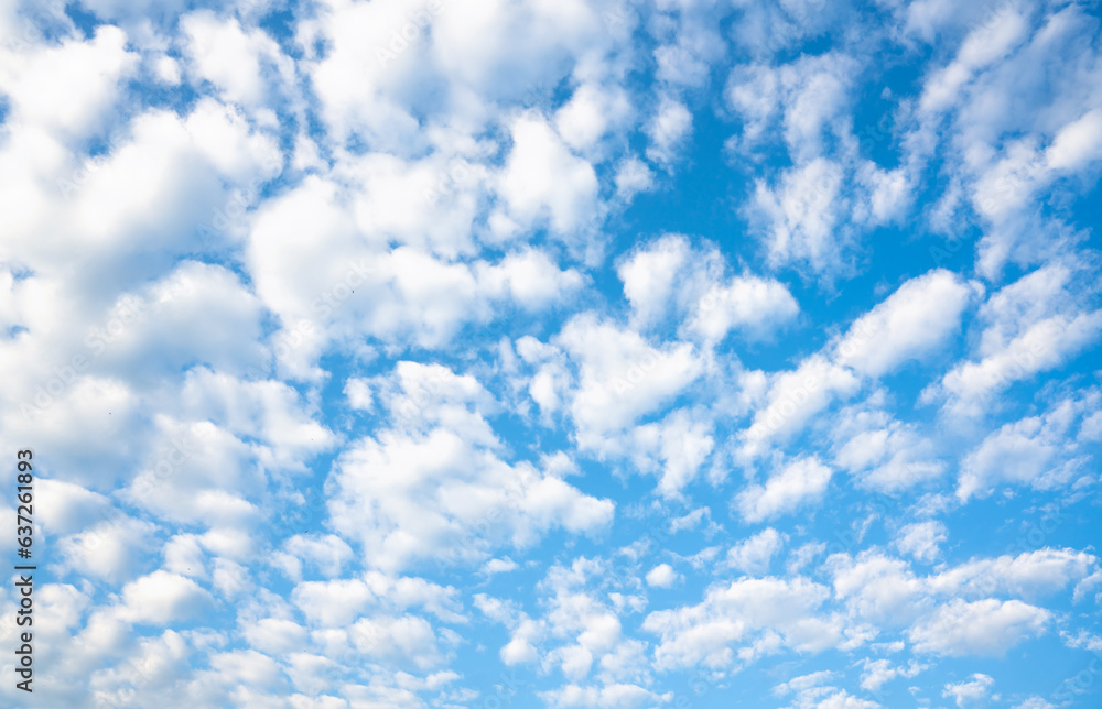 Fototapeta premium Clear blue sky with white porous clouds. Natural background. Selective focus.