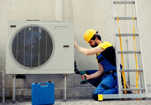 Canvas Print Competent repairman starting work on defective air conditioner, using handheld drill to disassemble condenser metal coil panel