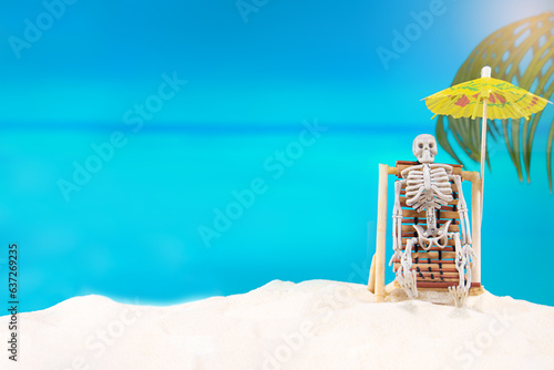 Skeleton on sunbed with umbrella enjoys beach day at sea. Halloween in hot country, burned out. Copy space