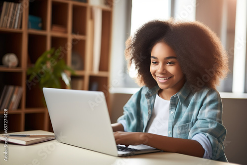 Happy African American teen student elearning at home on pc, writing notes. Smiling teenage girl using laptop watching webinar, hybrid learning english online virtual class, sitting at home table