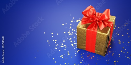 Golden Christmas gift decoration with red bow on a blue background.