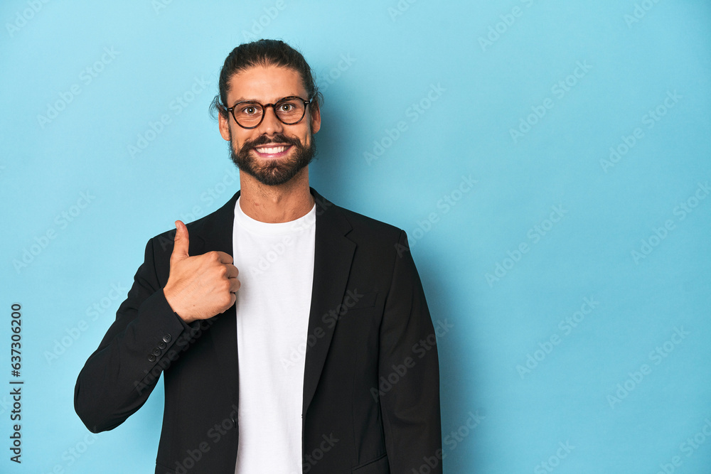 Businessman in suit with eyeglasses and beard smiling and raising thumb up Businessman in suit with eyeglasses and beard smiling and raising thumb up