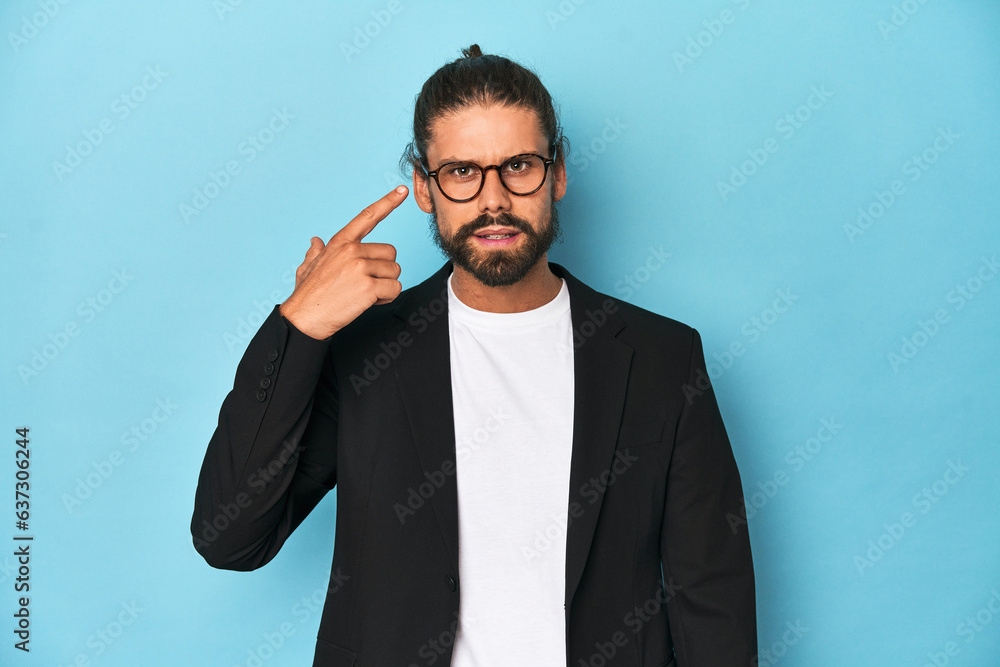 Businessman in suit with eyeglasses and beard showing a disappointment gesture with forefinger. Businessman in suit with eyeglasses and beard showing a disappointment gesture with forefinger.