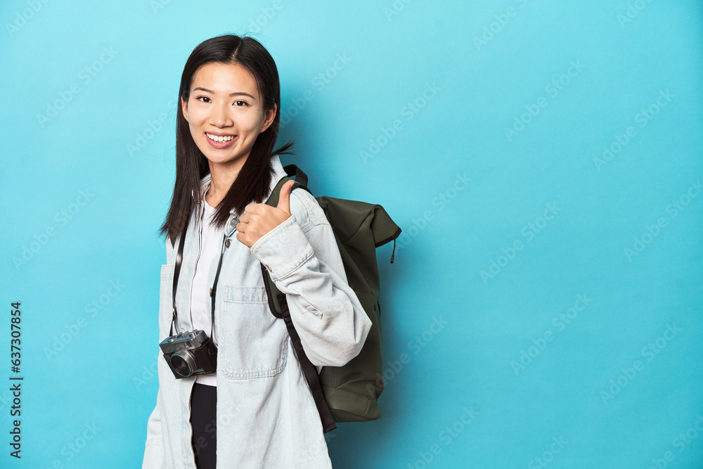 Young Asian traveler ready to capture adventures, smiling and raising thumb up Young Asian traveler ready to capture adventures, smiling and raising thumb up